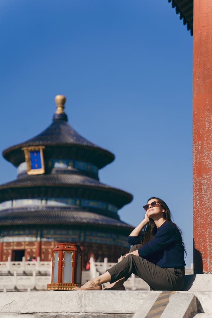 Turista sentada frente al Templo del Cielo durante un viaje a Beijing